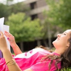 student smiles while looking at the sky